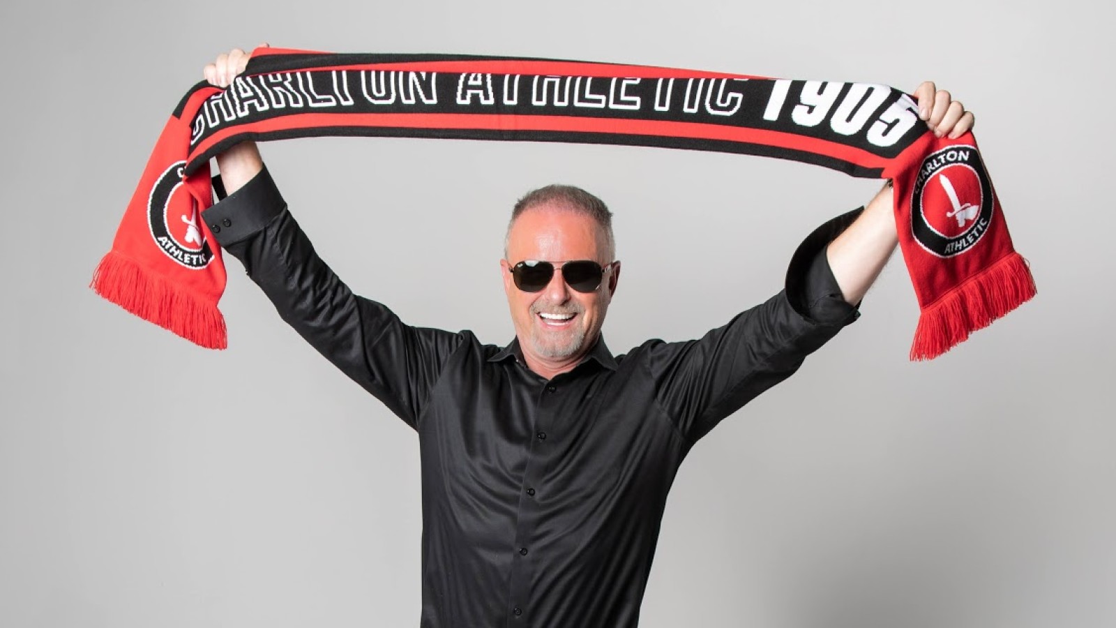 Thomas Sandgaard holds a Charlton scarf aloft