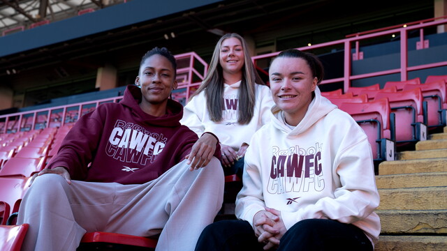 Elisha N'Dow, Jodie Hutton and Gillian Kenney wearing CAWFC wear in the stands at the valley