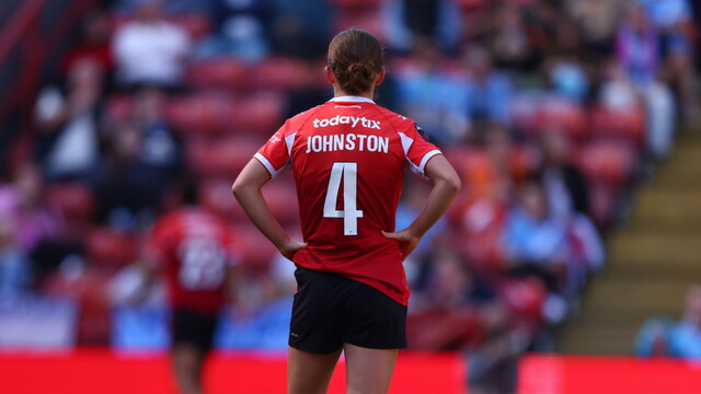 Grace Johnston standing with her back to the camera on the pitch at the valley