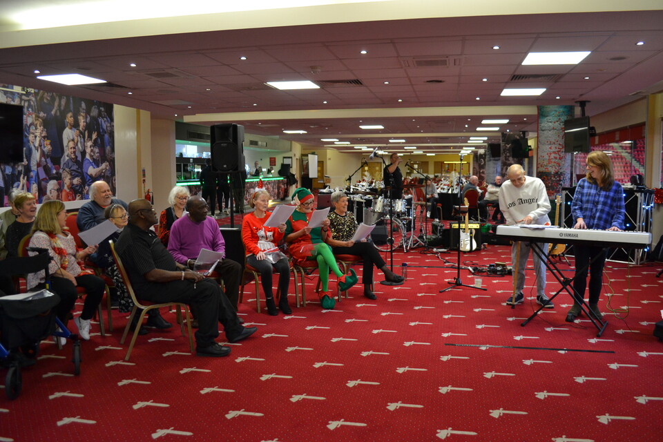 Extra Time members singing carols with a keyboard player