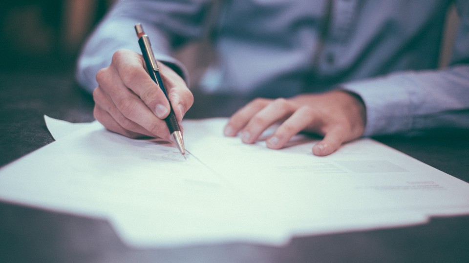 Image of person writing on a piece of paper