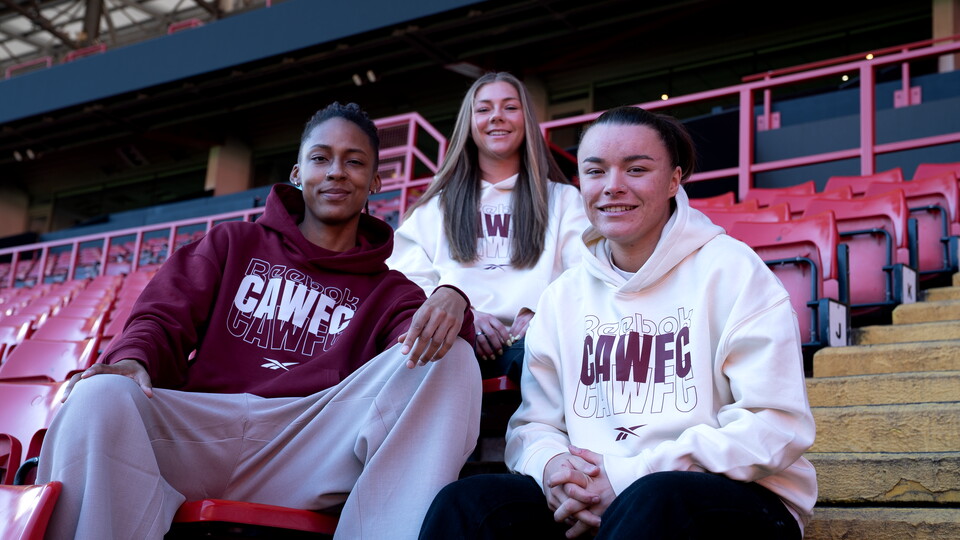 Elisha N'Dow, Jodie Hutton and Gillian Kenney wearing CAWFC wear in the stands at the valley