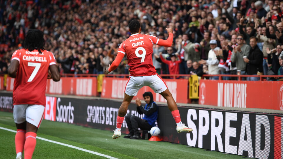 Karlan Grant celebrates in front of a busy Alan Curbishley Stand