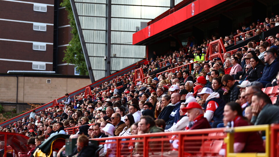 Large crowd in red and white shirts at football match
